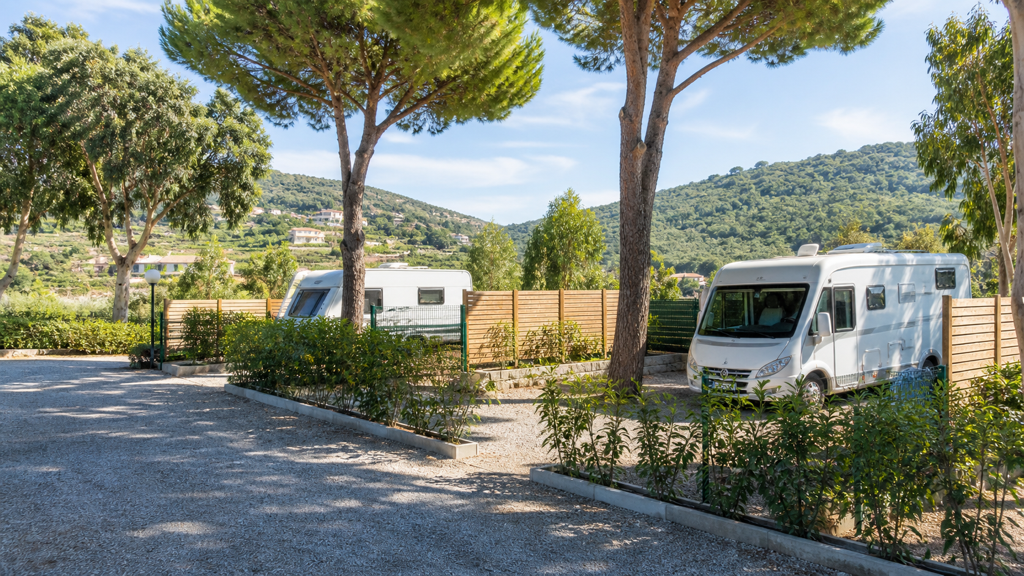 Camping sfeerfoto van terrassen met campers onder mediterrane pijnbomen bij Ventimiglia