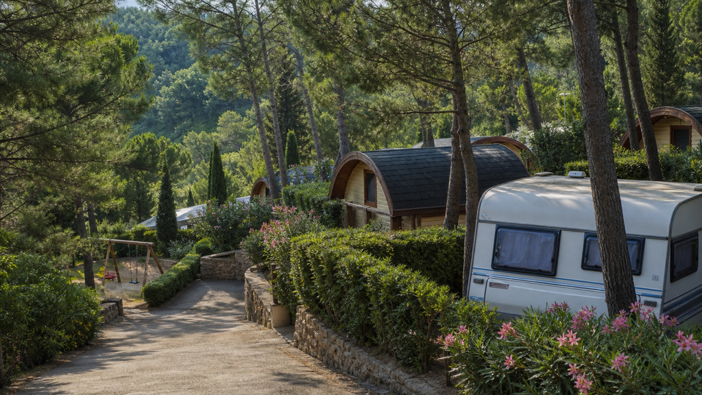 Camping sfeerfoto van bungalows en caravan tussen pijnbomen en oleanders bij Deiva Marina