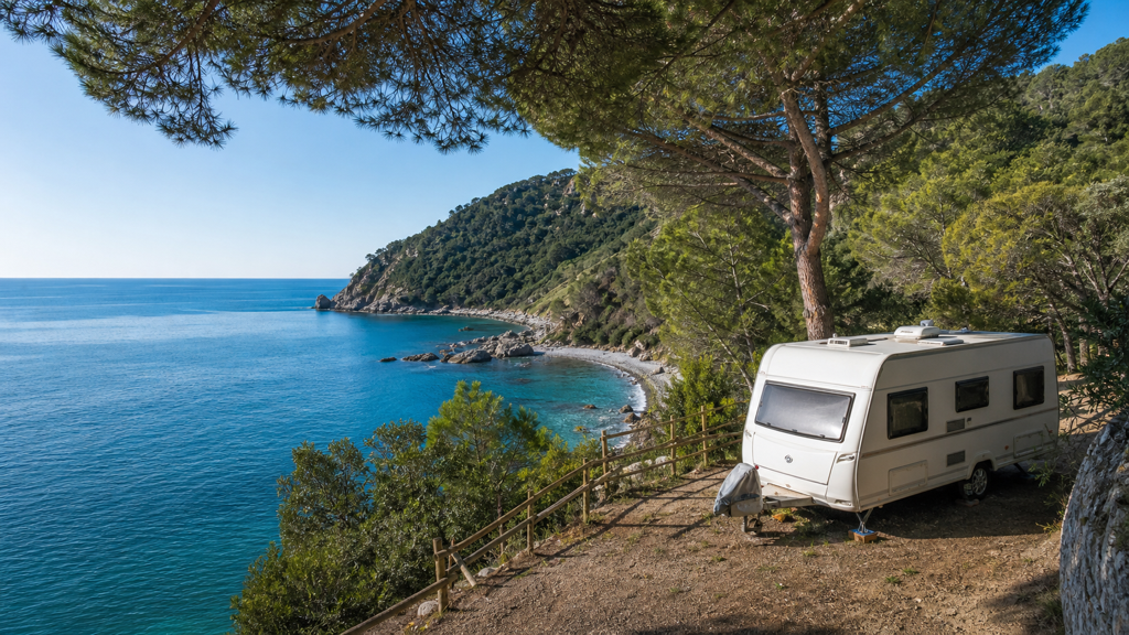 Camping sfeerfoto van een terrasplaats boven een rots- en kiezelbaai bij Moneglia