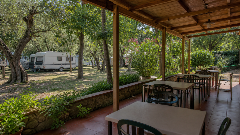 Camping sfeerfoto van een restaurantterras tussen olijfbomen en caravans bij Sestri Levante