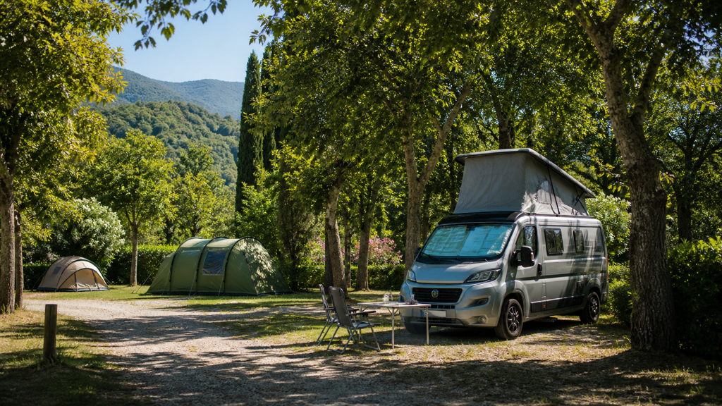 Camping sfeerfoto van tenten en een camper onder volwassen bomen bij Levanto